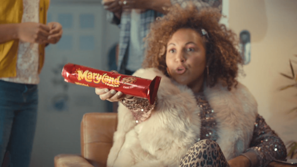 Woman in a fur coat holding a Maryland cookies pack